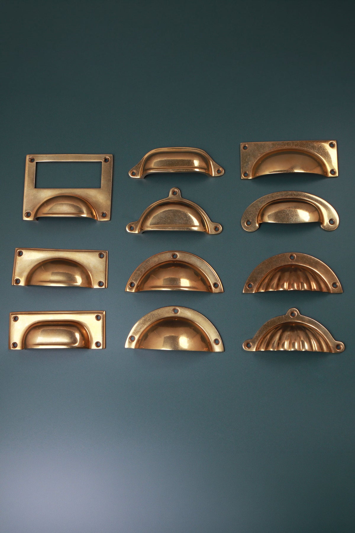 All eleven aged brass cup pull styles laid out together