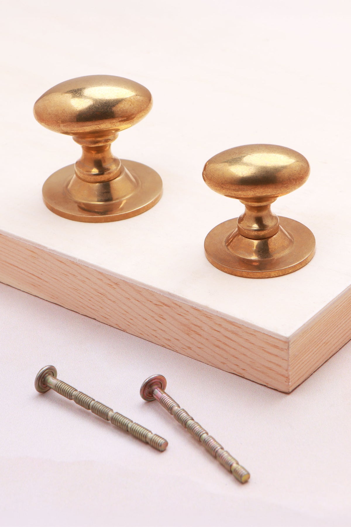 Oval cabinet knob on rose in aged brass