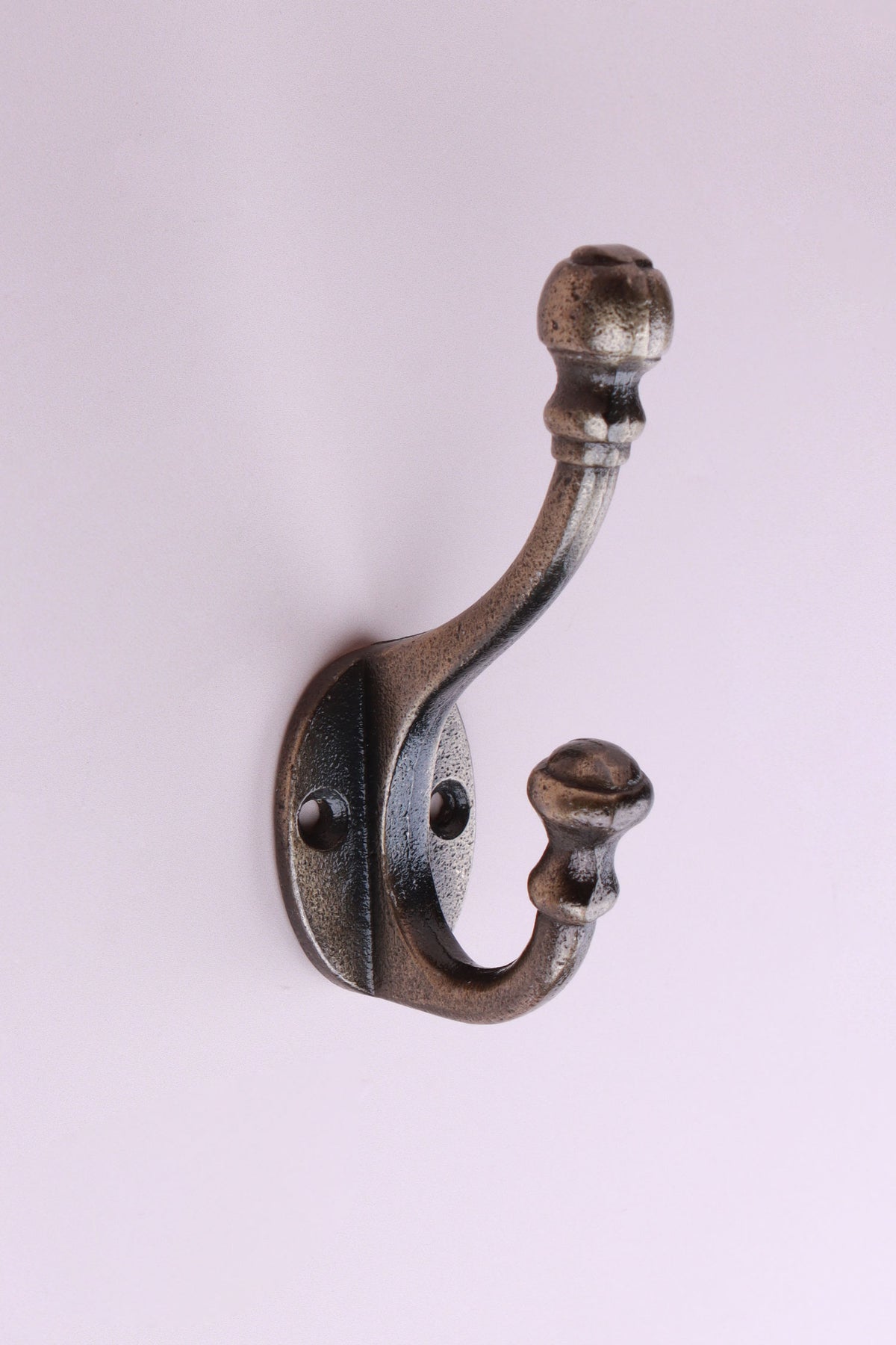 Ball Finial Hook: cast iron double hook with a ball top on a turned collar and a flared lower tip, on an oval back plate, antique brass finish