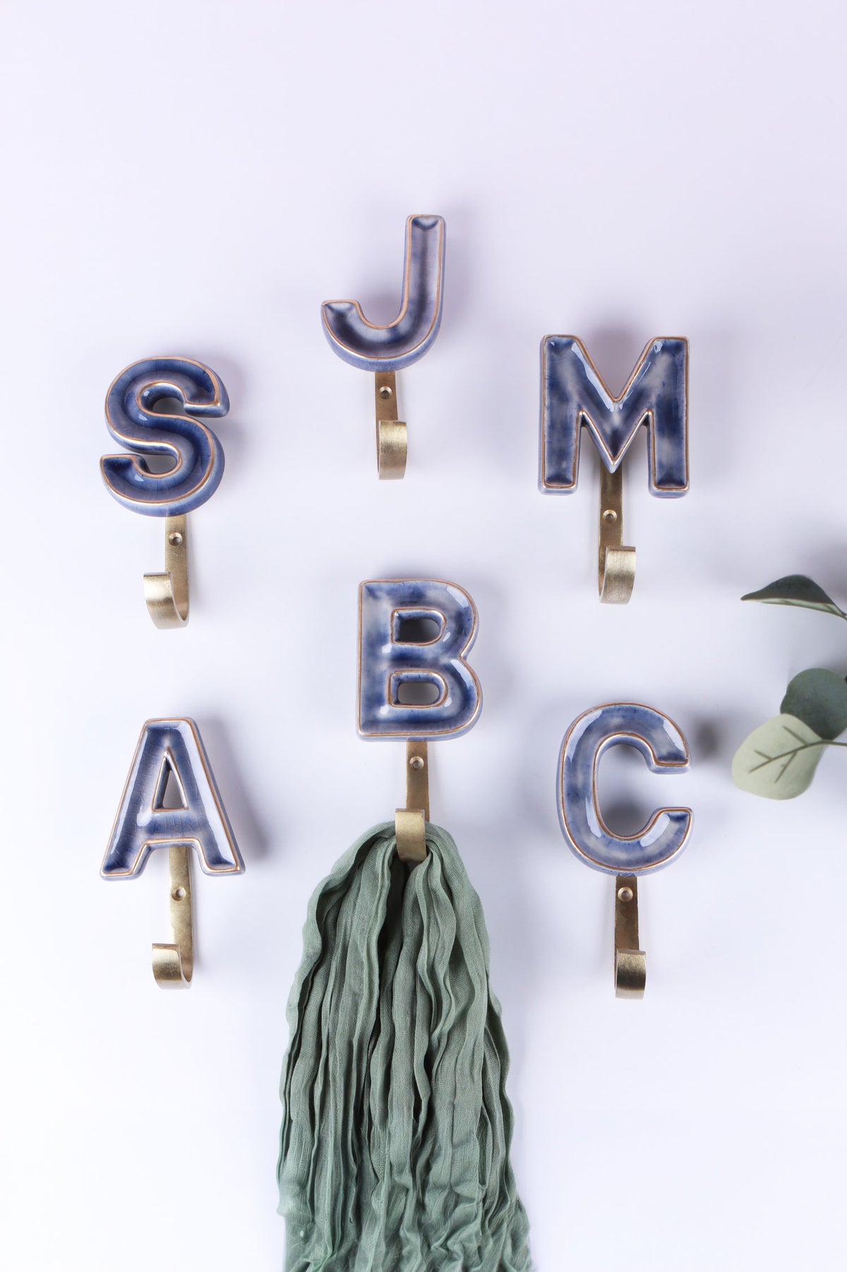 Blue ceramic letter hooks on the wall, third view