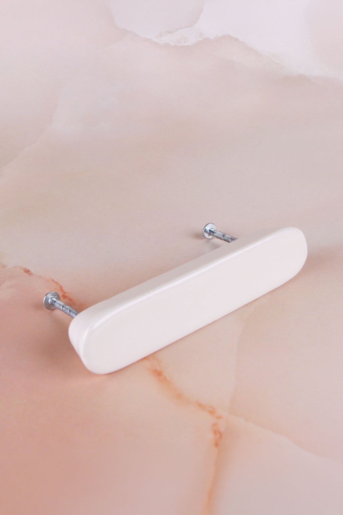Cream ceramic bar handle with its two fixing bolts