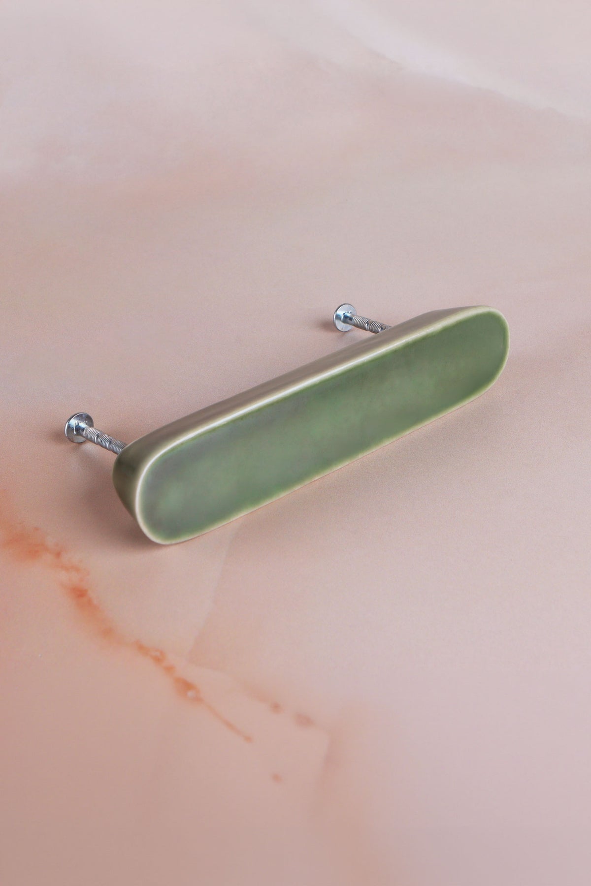 Olive green ceramic bar handle with a fine crackle glaze and its two fixing bolts