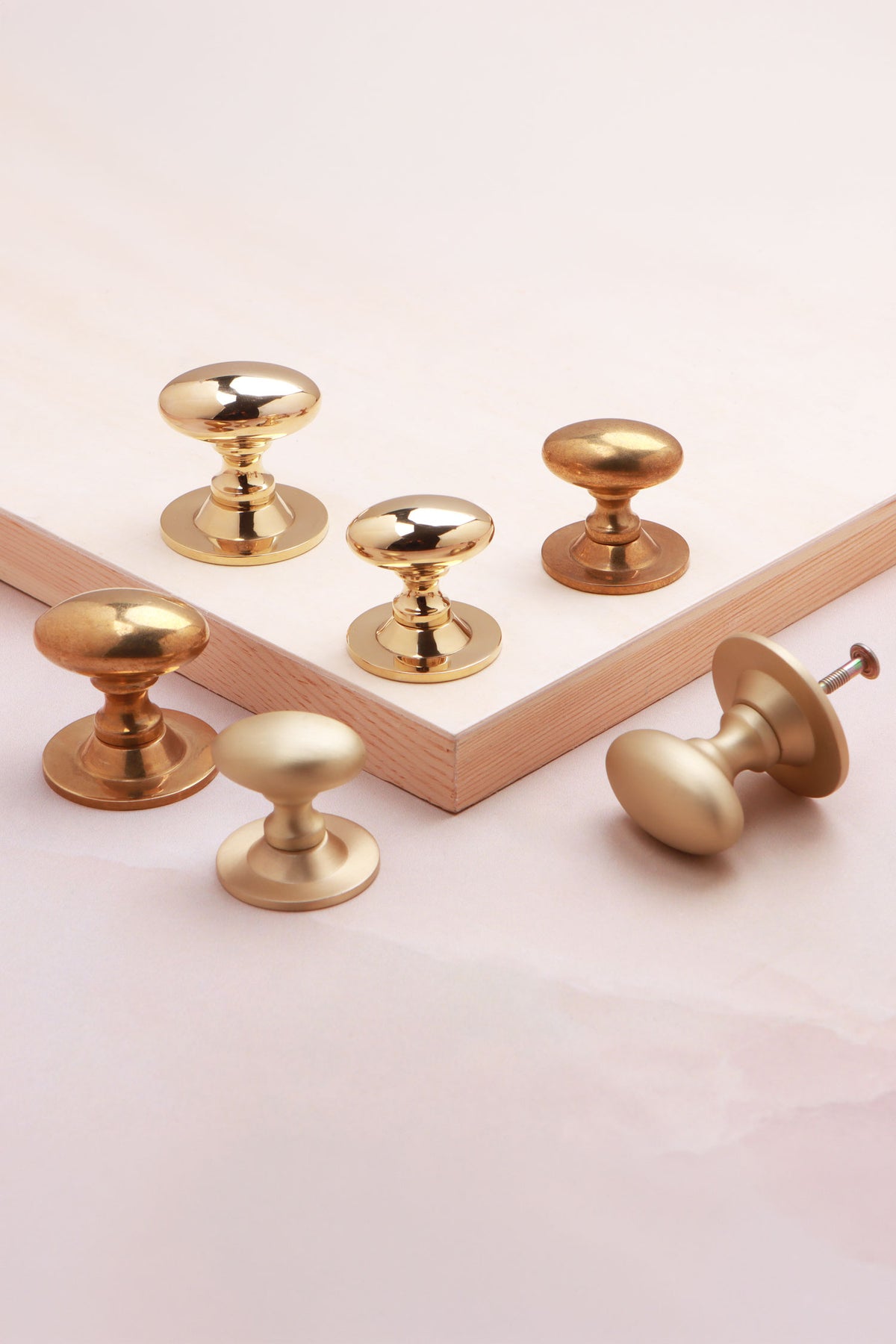 Oval cabinet knob on rose in polished, aged and satin brass, third view