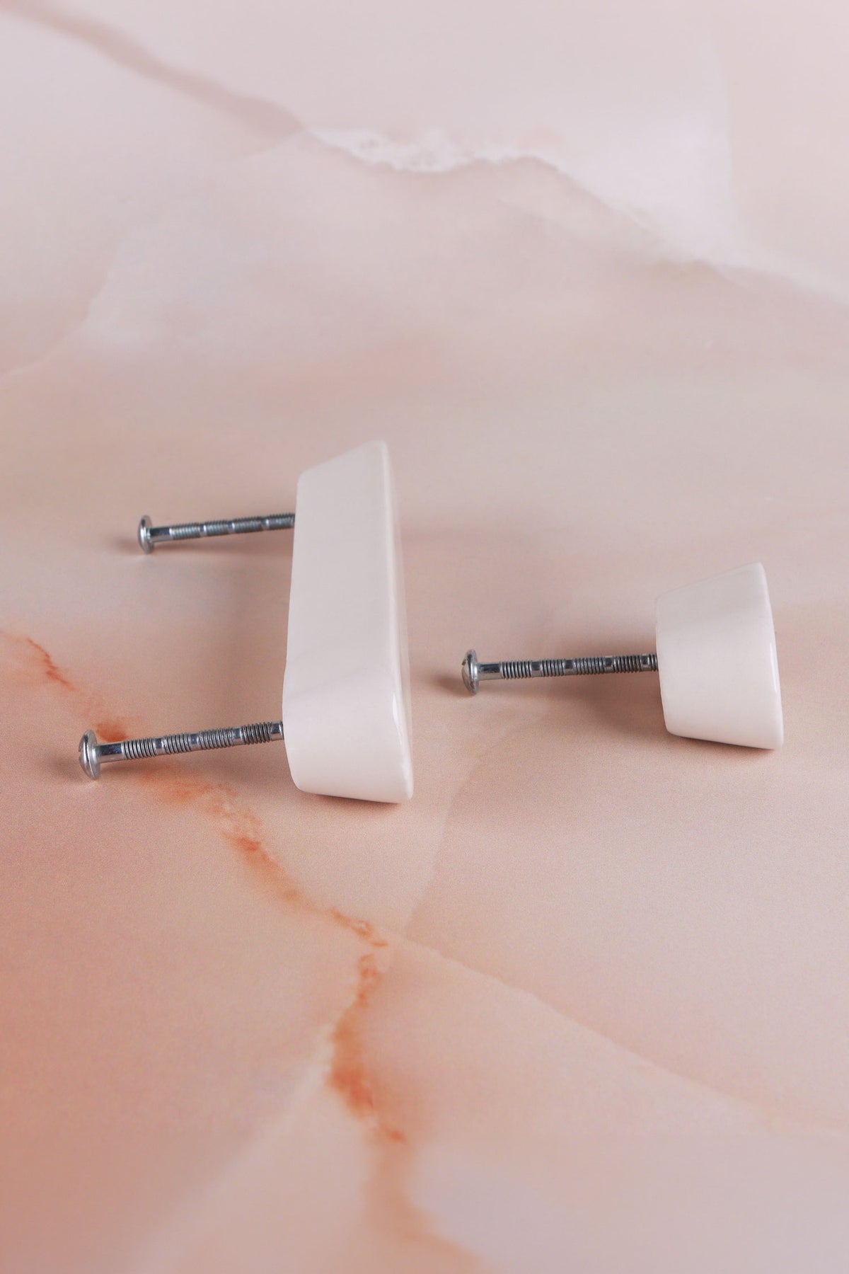 Side view of the cream knob and the cream handle, showing their tapered shape and the fixing bolts