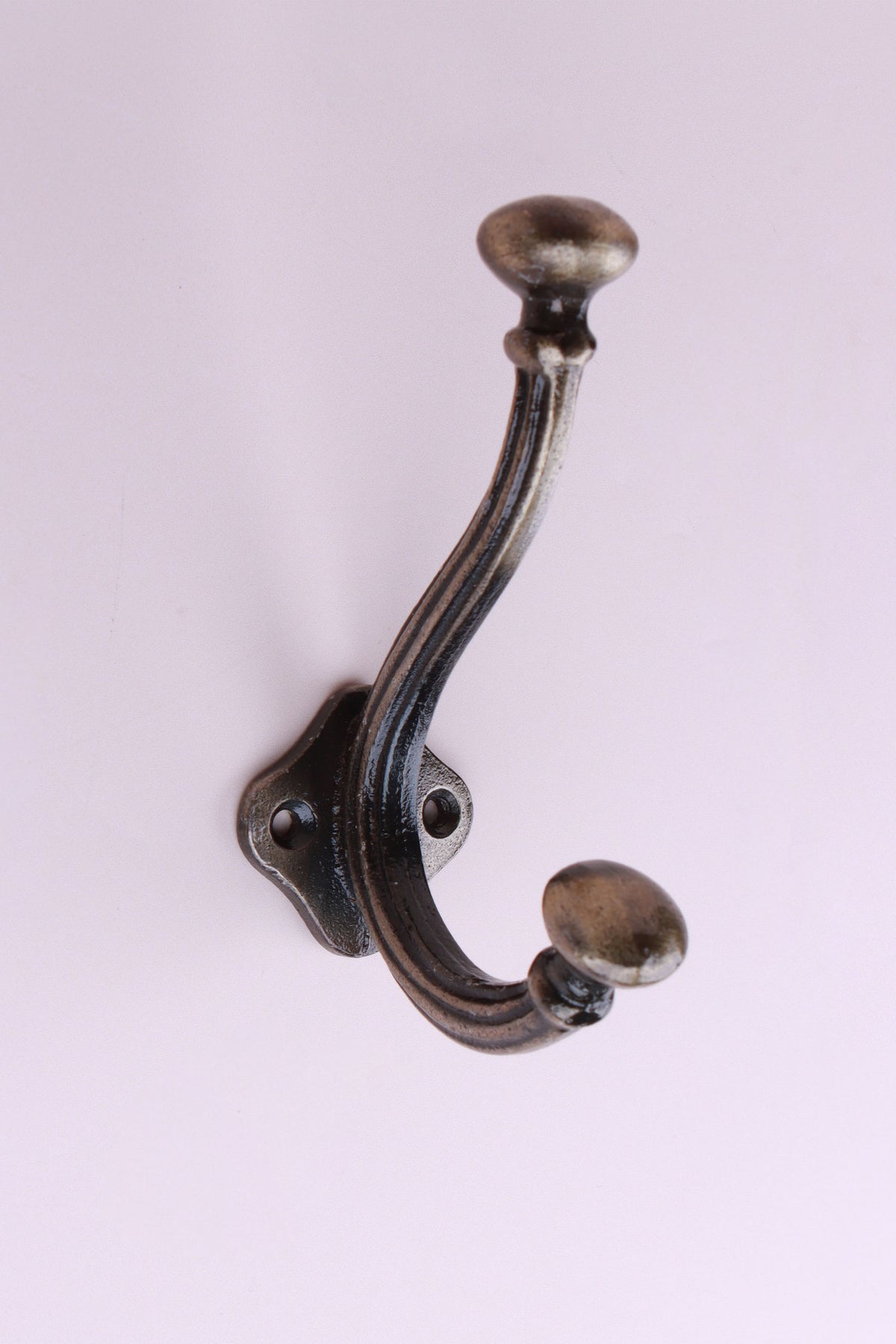Oval Knob Hook: cast iron double hook with oval knob ends, on a shaped back plate, antique brass finish