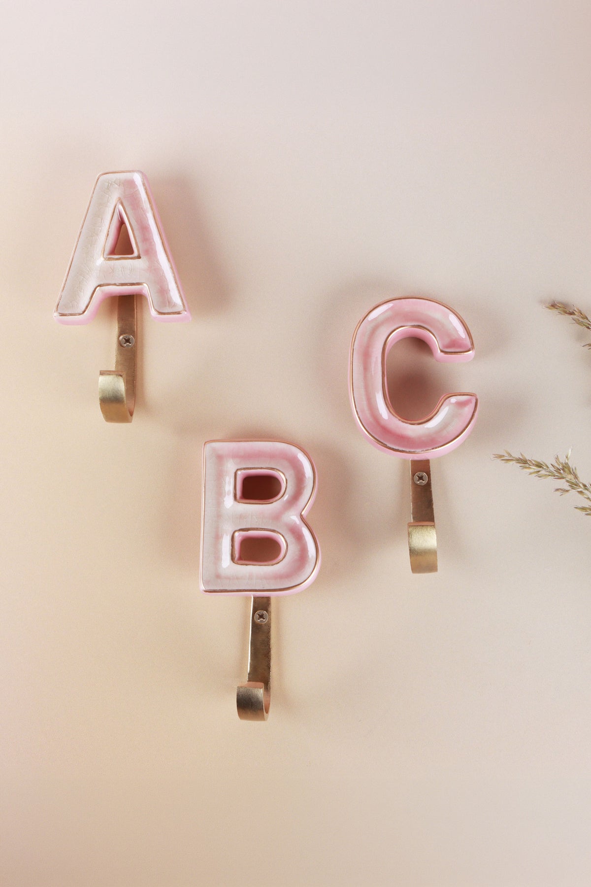 Pink ceramic letter hooks on the wall, second view