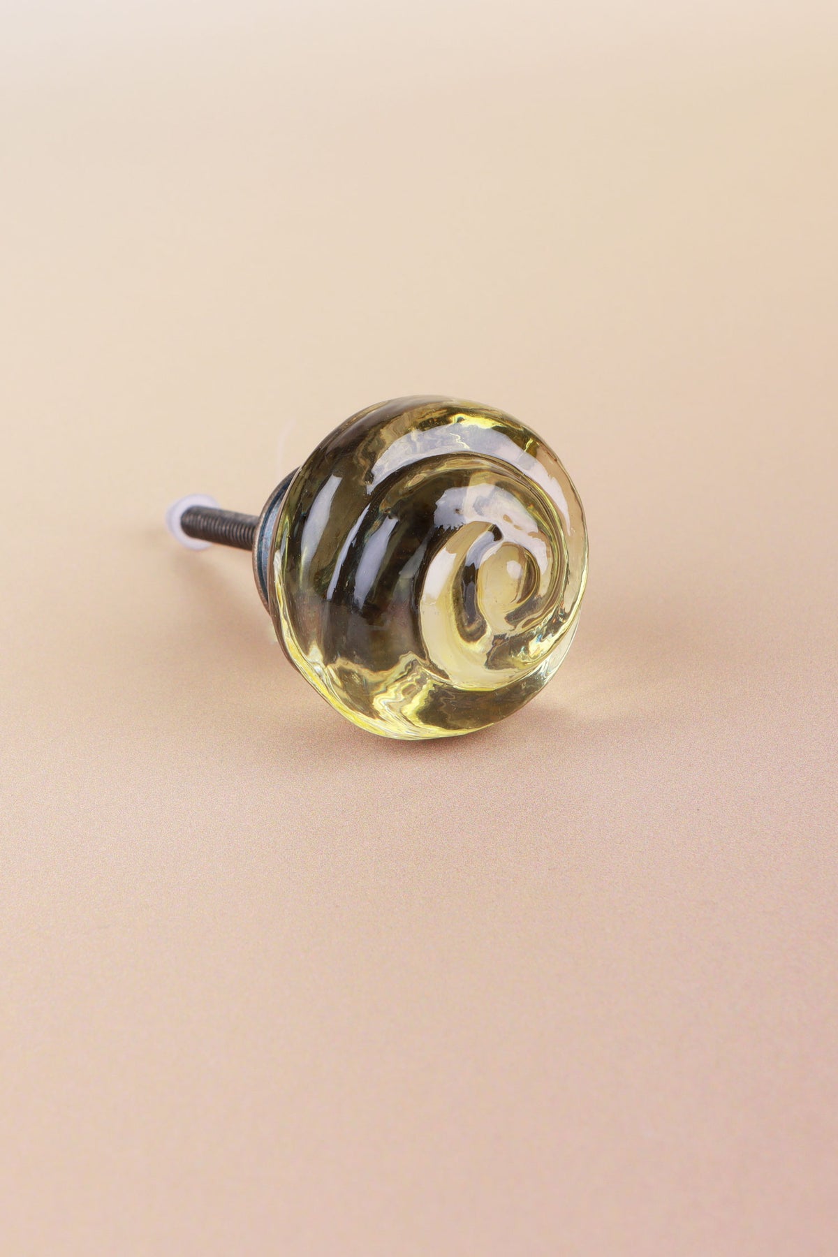 Ivory small rose glass cabinet knob, a pale champagne tint, with a swirl curling into the centre, on an antique brass finish base