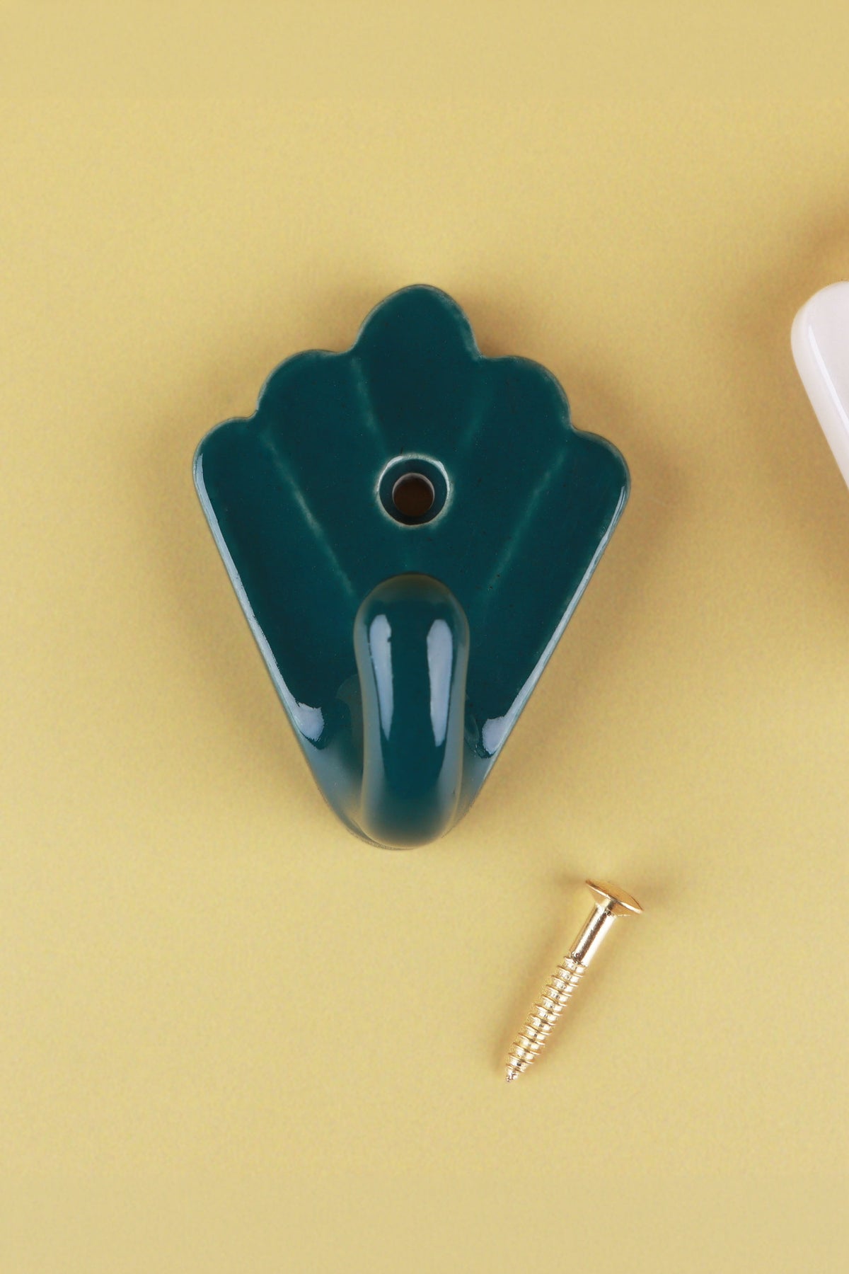 Dark teal scallop shell ceramic wall hook, a deep glossy teal green, with its brass screw