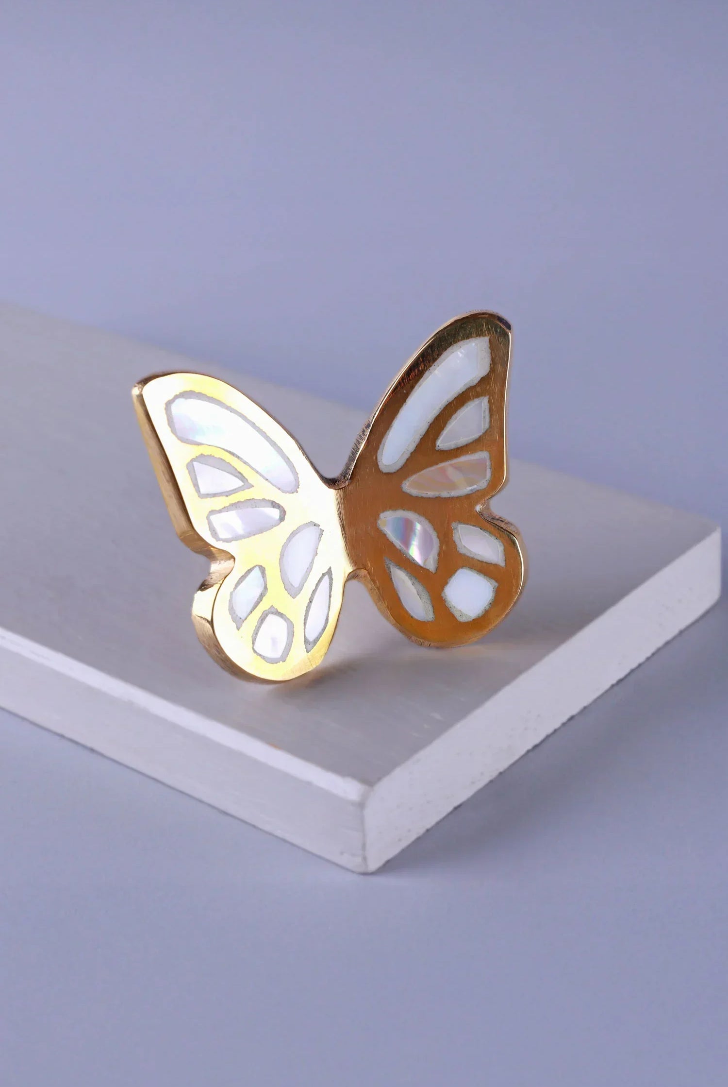 Gold butterfly cabinet knob with white inlay from G Decor on a white surface
