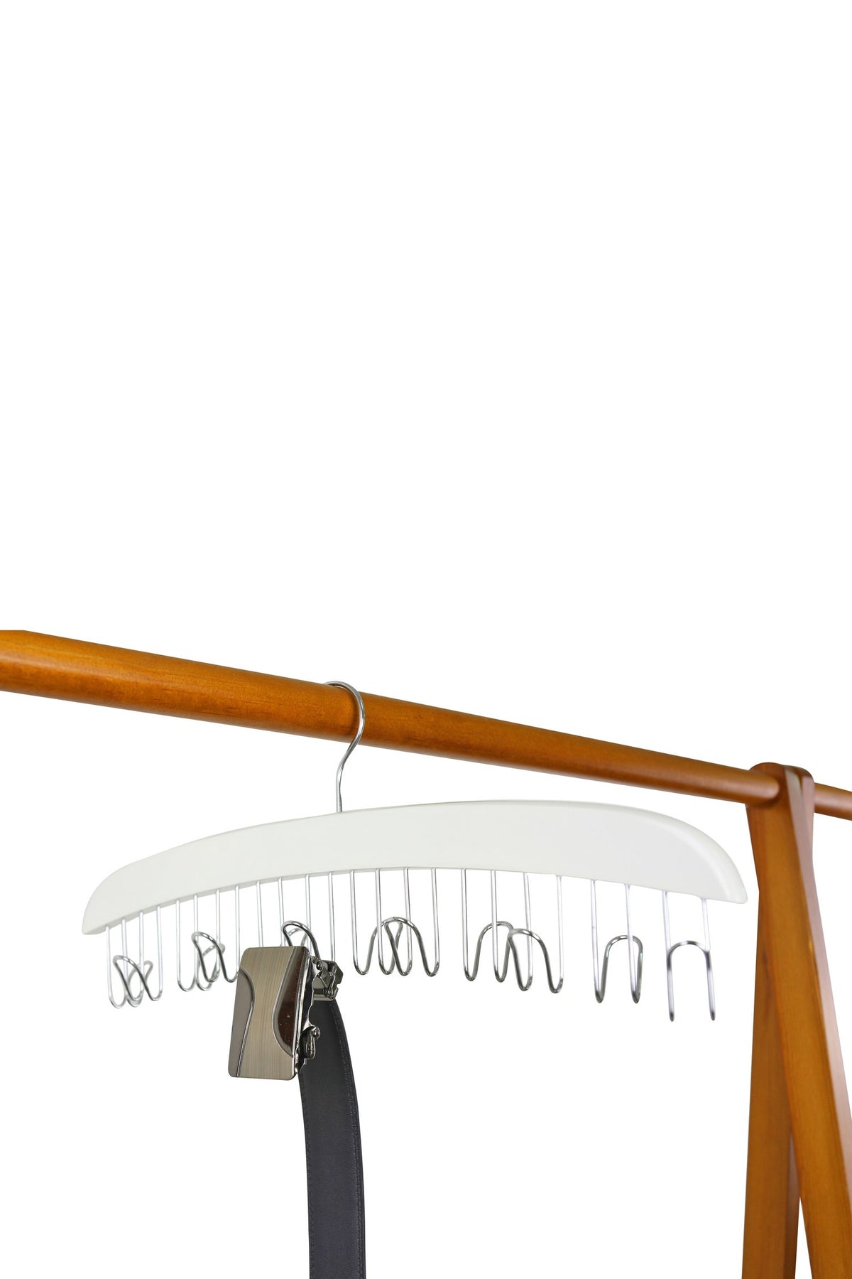 White wooden belt hanger on a wooden rail, holding a black belt by its buckle