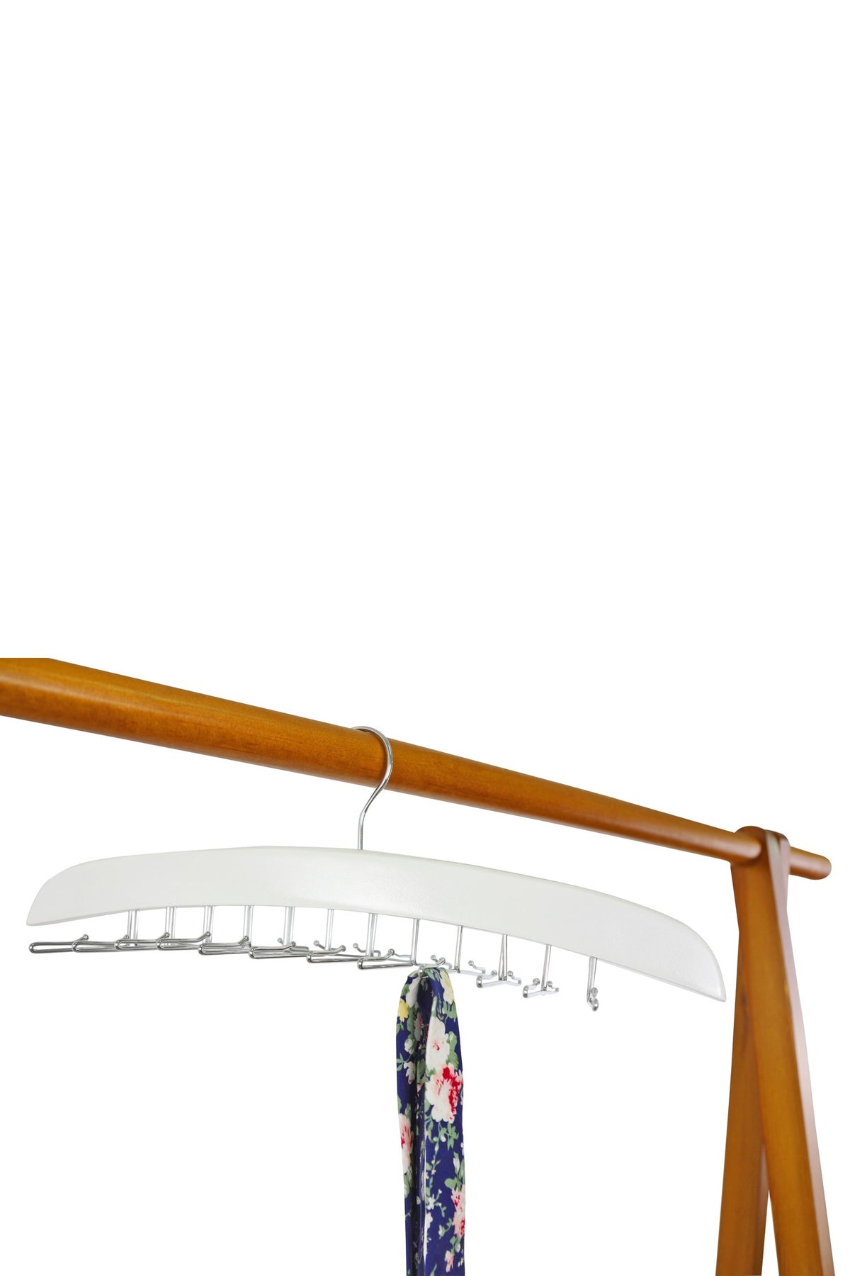 White wooden tie hanger on a wooden rail, holding a floral tie