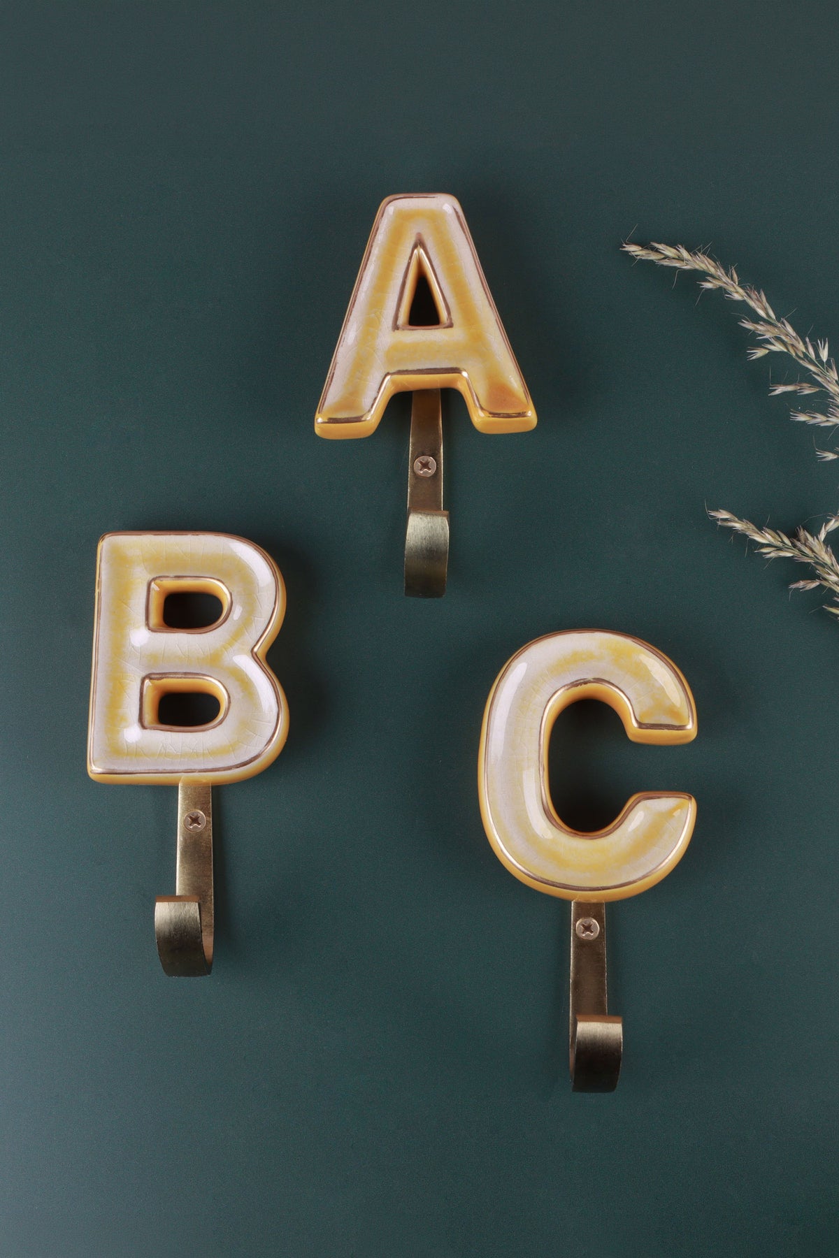 Yellow ceramic letter hooks on the wall, second view