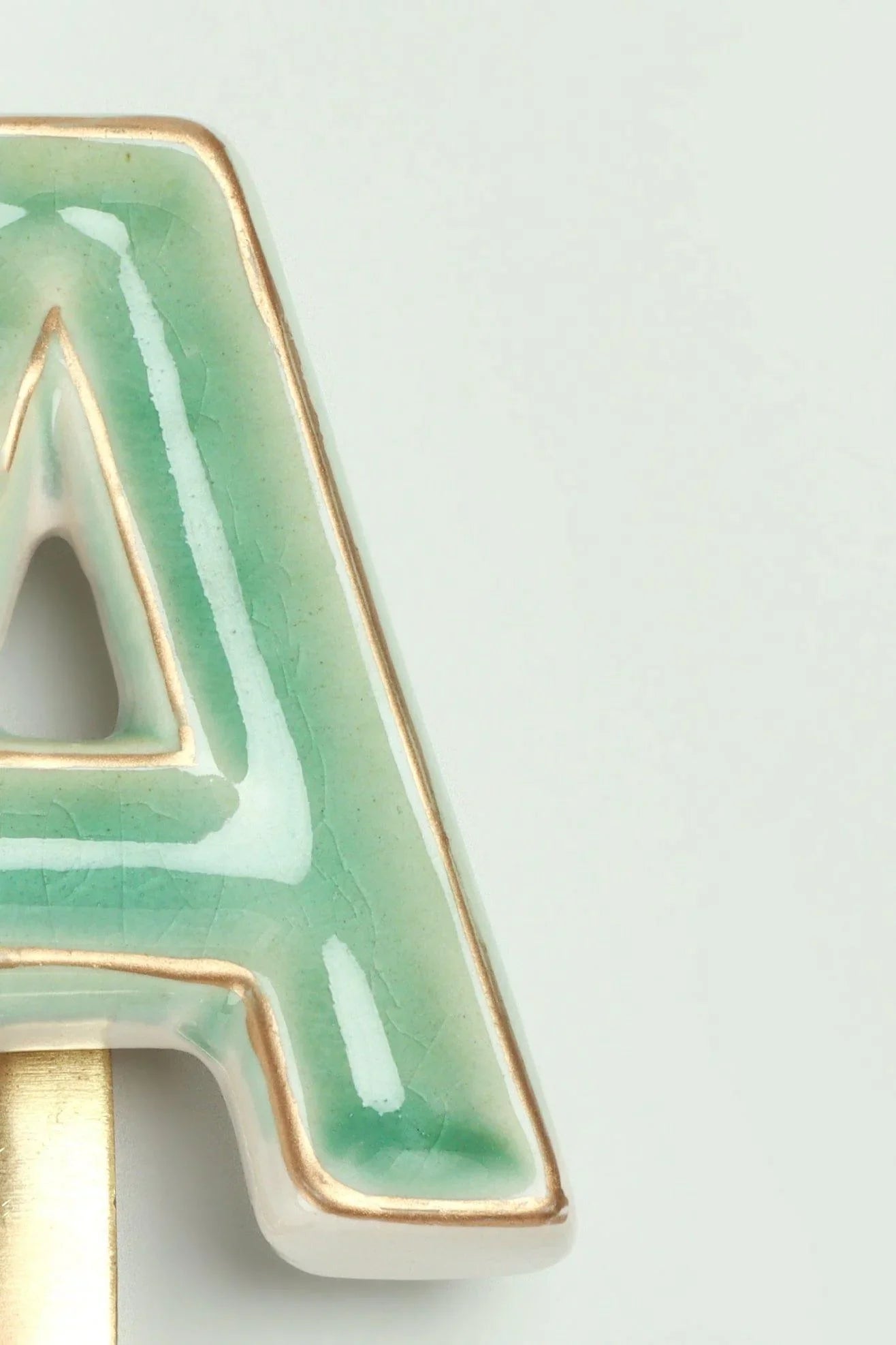 Green crackle alphabet coat hook close-up — hand-painted ceramic with brass letter, G Decor