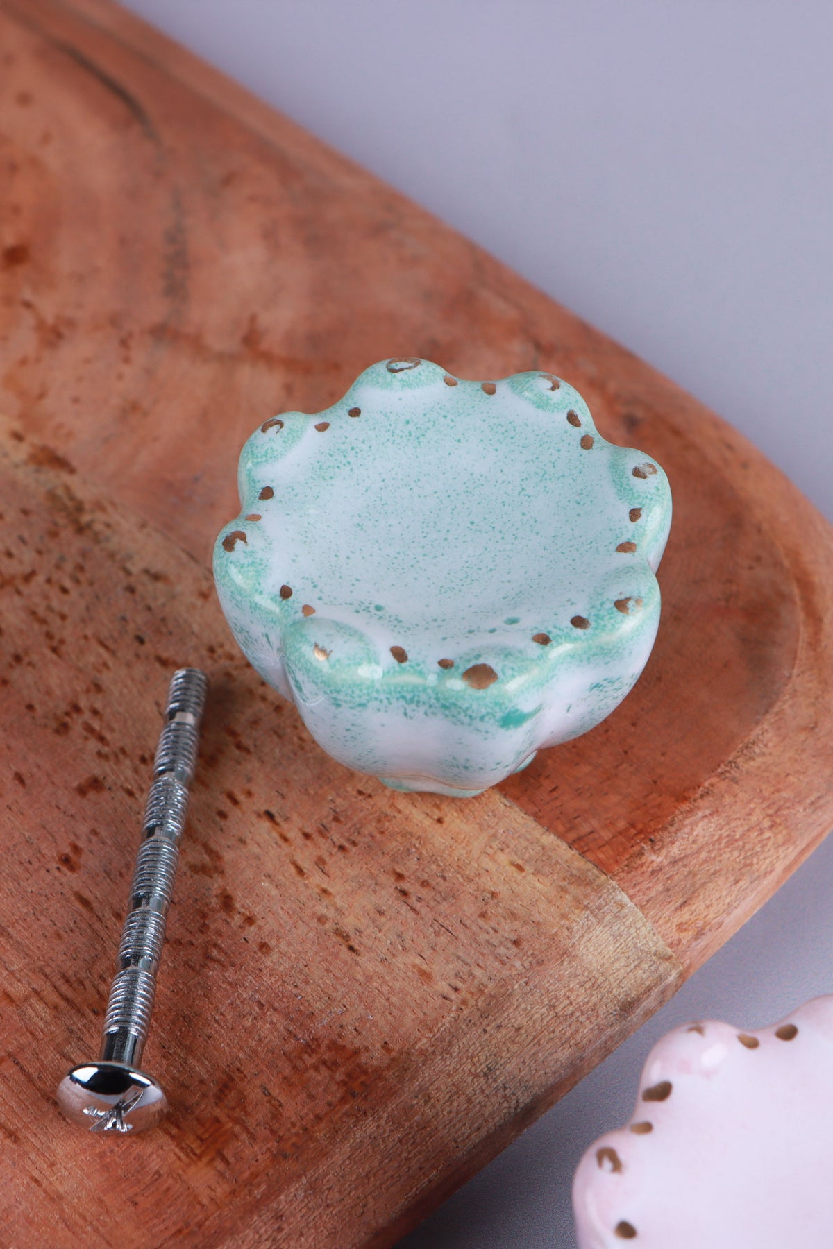 Turquoise scalloped ceramic drawer knob with gold-coloured dots, beside its M4 bolt