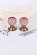 Pair of blush pink faceted glass mortice door knobs on antique brass roses, with the square spindles and fixing screws