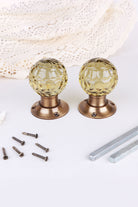 Pair of ivory faceted glass mortice door knobs on antique brass roses, with the square spindles and fixing screws
