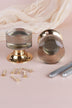 Pair of clear glass cylinder mortice door knobs on polished brass roses, one standing and one on its side, with the square spindles and fixing screws