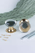 Pair of clear glass dome mortice door knobs on polished brass roses, one standing and one on its side, with the square spindles and fixing screws