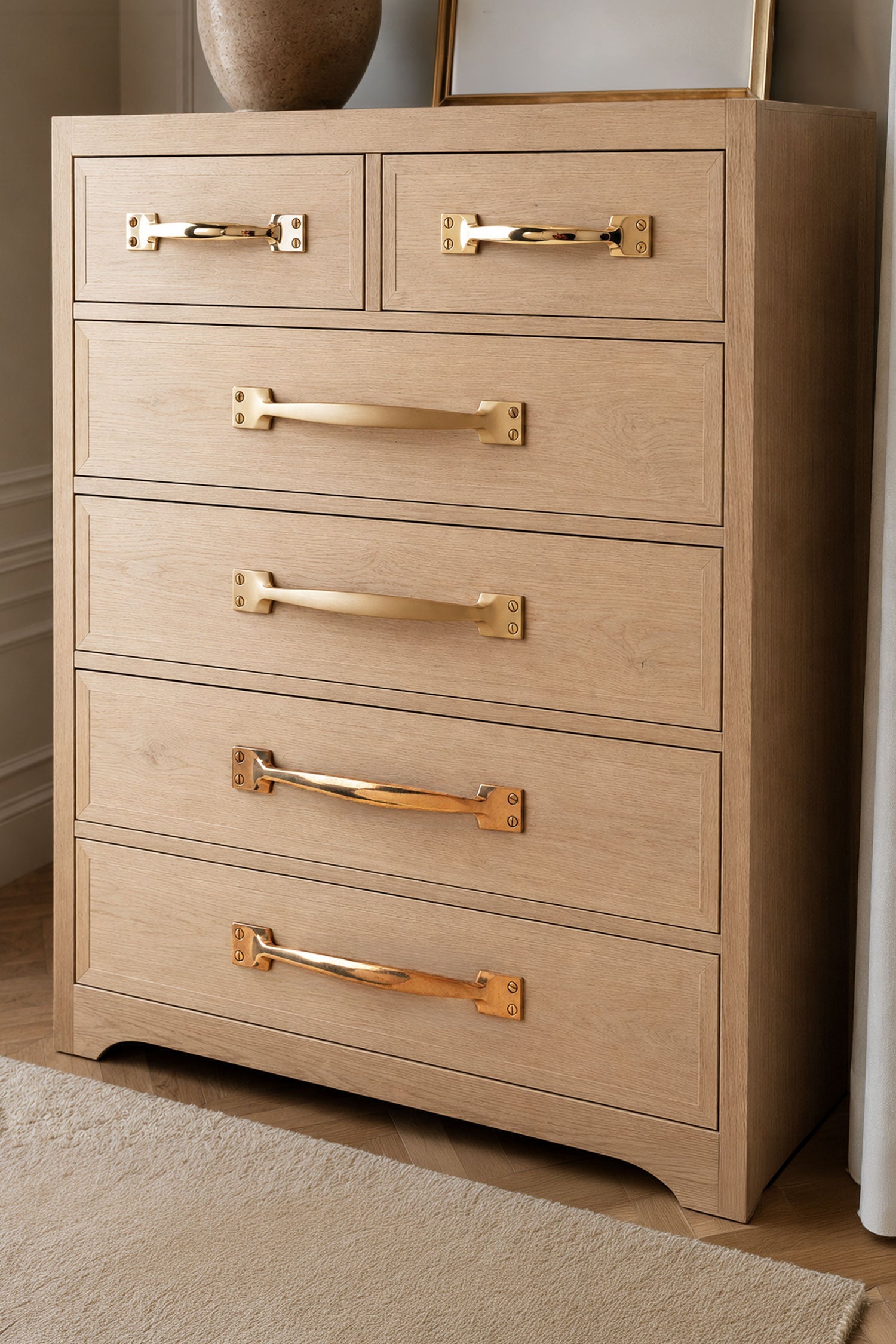 Brass pull handles fitted to a chest of drawers