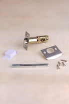 Tubular mortice latch with white ceramic door knobs fitted to a door edge, with strike plate and screws