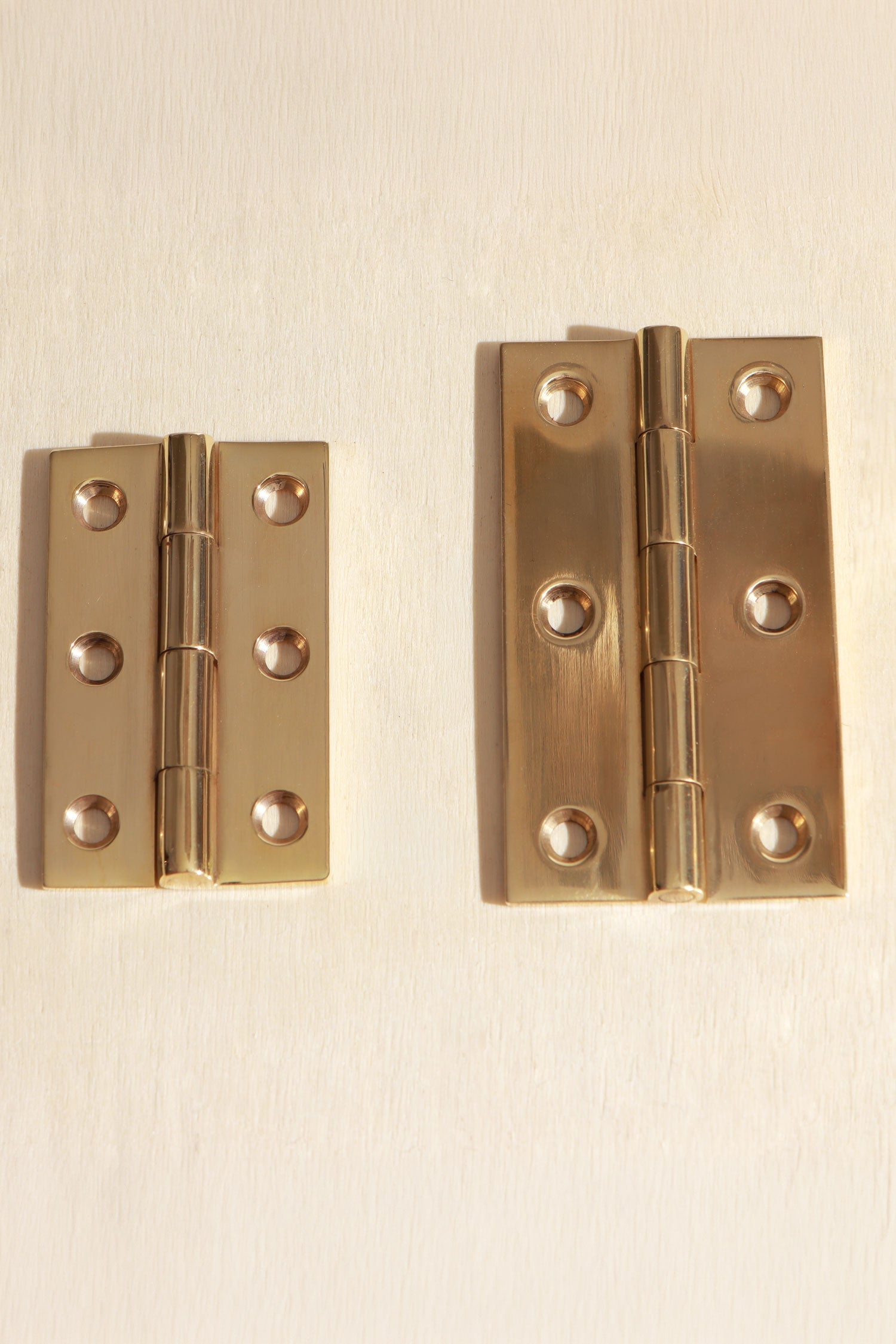 Polished brass butt hinges, both sizes side by side