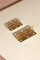 Polished brass butt hinge open, showing the knuckle and solid brass screws