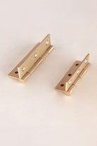 Satin brass butt hinge open, showing knuckle and pin