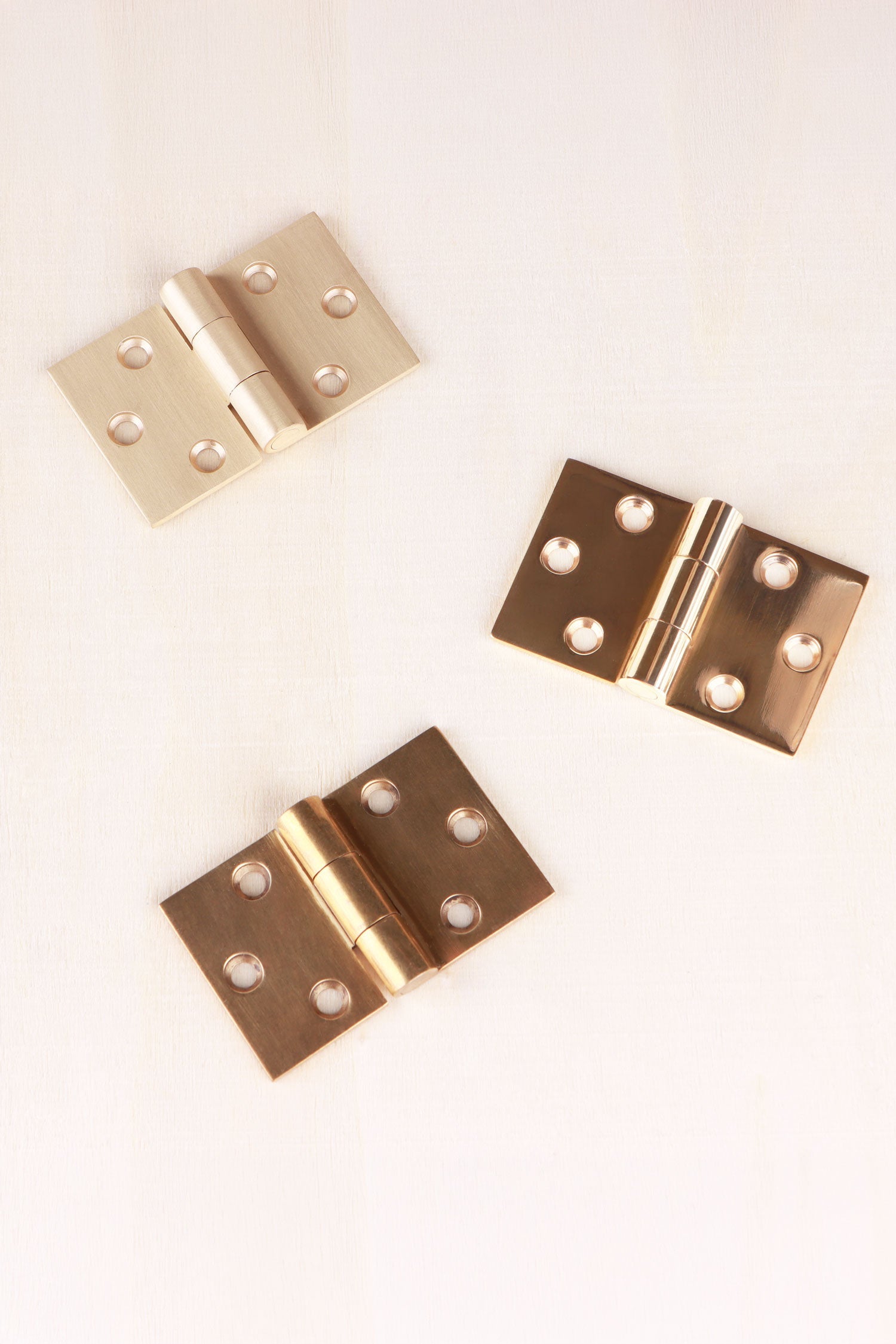 Three finishes of the brass backflap hinge side by side