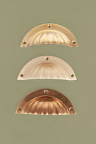 Fluted brass cup pulls grouped, showing the wide flange