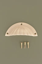 Fluted cup pull in satin brass, lacquered finish