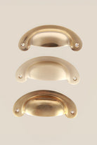 Slim Crescent brass cup pulls grouped, showing the shallow curve