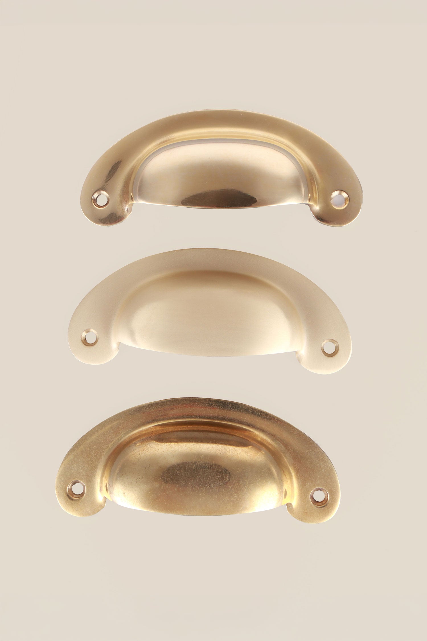 Slim Crescent brass cup pulls grouped, showing the shallow curve