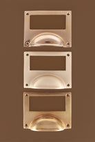 Card frame cup pulls grouped, showing the brass label window