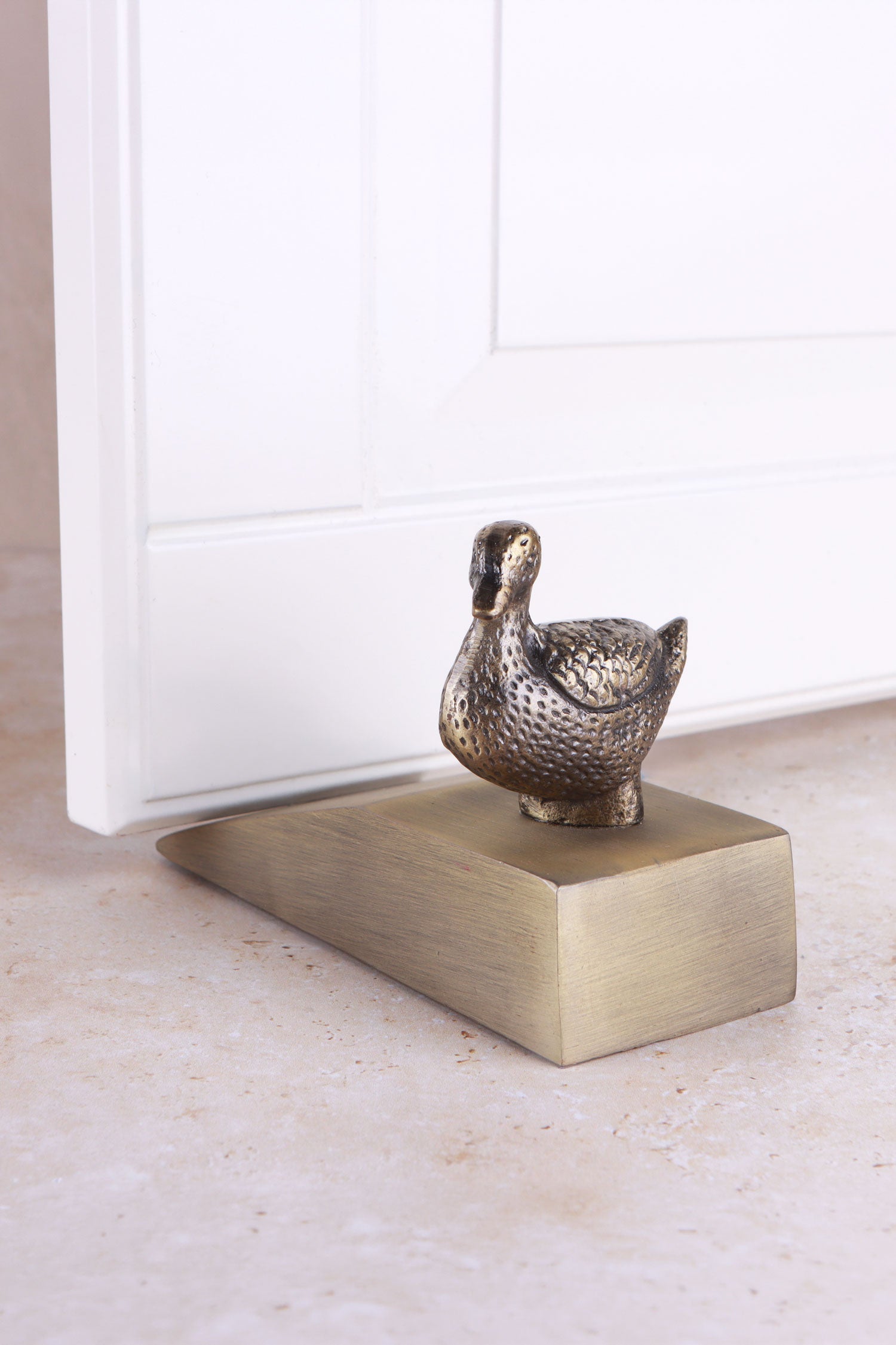 Duck door stopper in antique brass