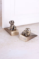 Companion cat and dog door stoppers in antique brass