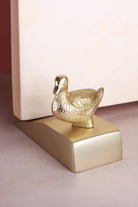 Duck door stopper in polished brass