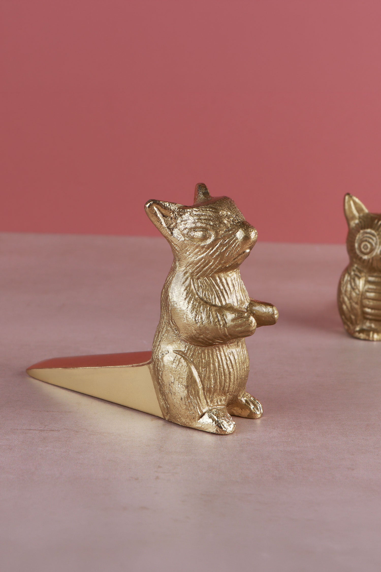 Squirrel door stopper in polished brass, side view