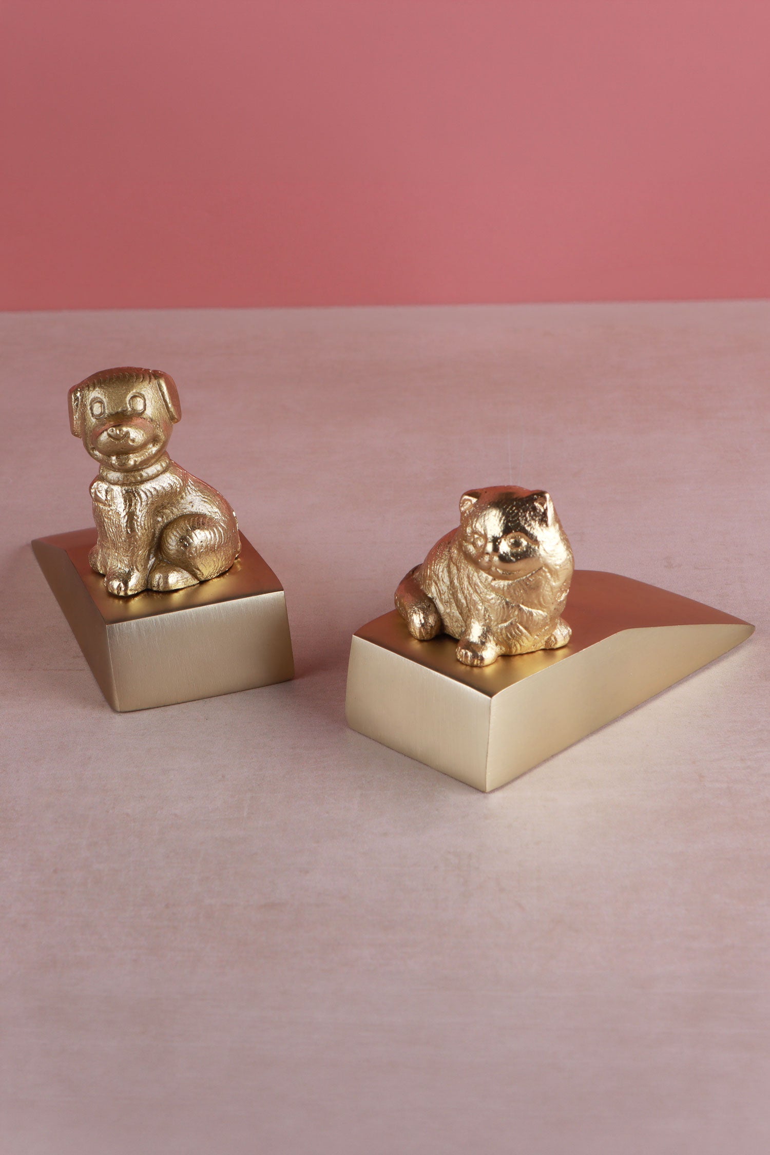Companion cat and dog door stoppers in polished brass