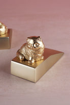 Cat door stopper in polished brass, close detail of the cast figure