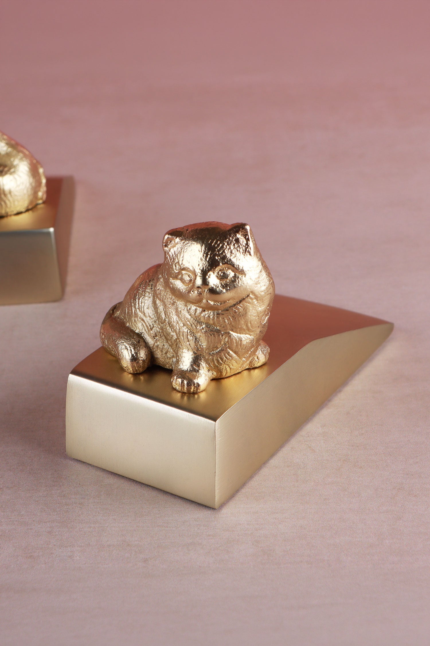 Cat door stopper in polished brass, close detail of the cast figure