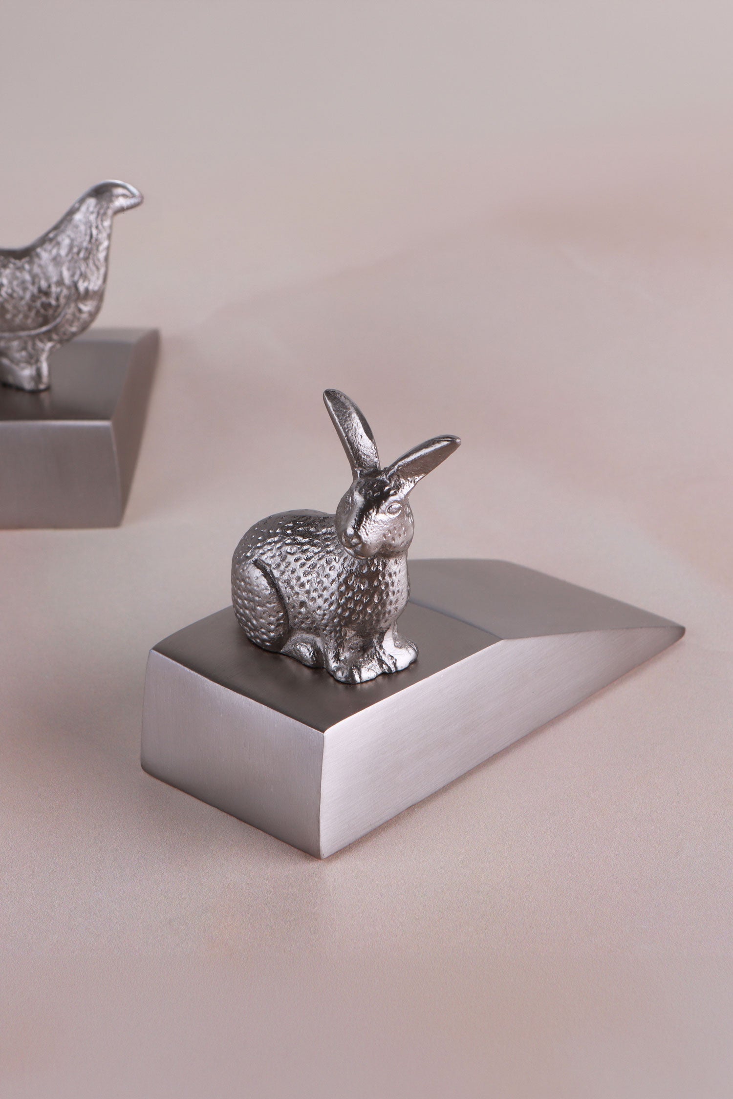 Rabbit door stopper in chrome on a weighted wedge base