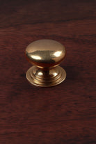 Bun aged brass cabinet knob, domed on a stepped rose, 32mm