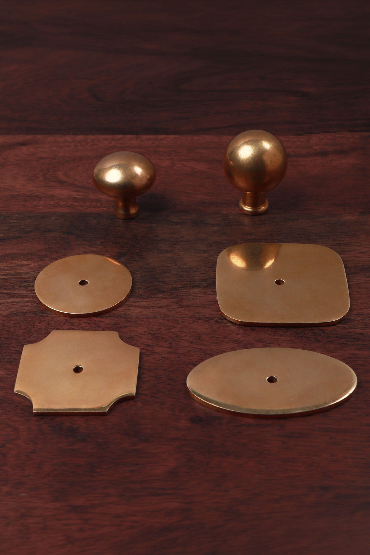Aged brass cabinet knobs shown with matching brass backplates