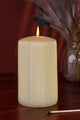 Textured ivory pillar candle by G Decor on wooden table with vase and matchstick