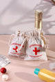 Hangover kit recovery pouches with red cross on table, surrounded by bottle and tablets, G Decor.