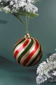Luxury red, green, and gold striped Christmas bauble on snowy pine branch, G Decor