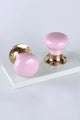 Pair of G Decor luxury pink ceramic and gold door knobs on white background