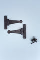 Pair of black metal T-hinges with screws on light background, luxury hardware by G Decor