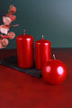 Glossy red pillar and round candles on a black tray with eucalyptus décor, luxury home accents