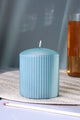 Blue ribbed pillar candle from G Decor on a woven placemat, luxury home décor accent